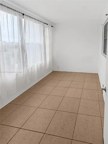 a view of a livingroom with an empty space and a window