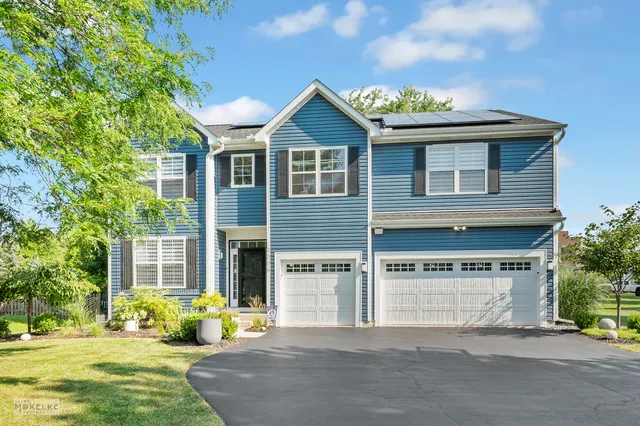 a front view of a house with a garden and plants