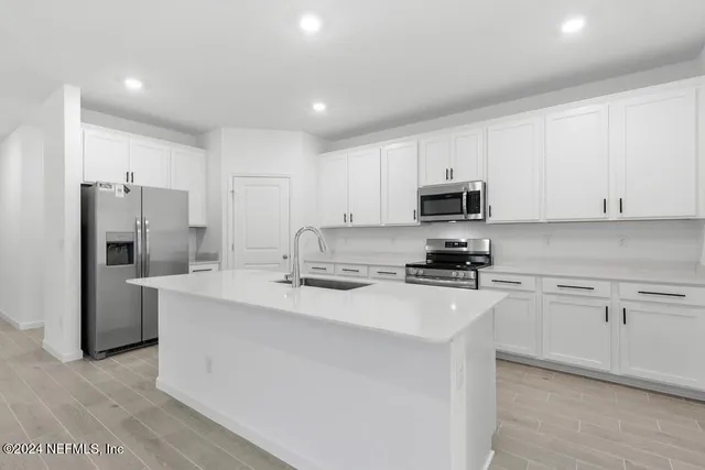 a kitchen with stainless steel appliances granite countertop a refrigerator stove microwave and sink