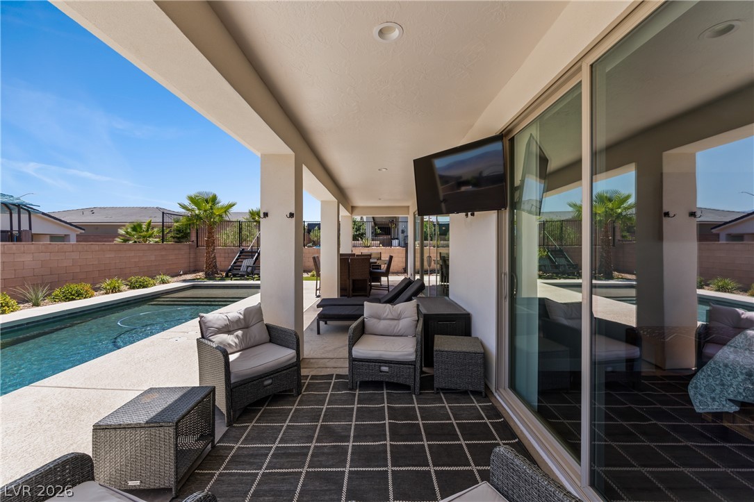 1436 Manassas Ridge Mesquite, NV 89027 - Photo 48 of 77 An inviting covered patio opens to a refreshing pool, offering an ideal space for outdoor relaxation.