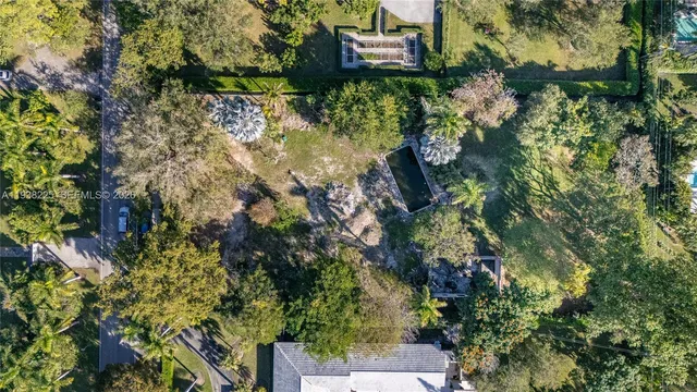 an aerial view of residential house with outdoor space and trees all around