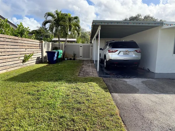 a view of a back yard of the house with a car parked