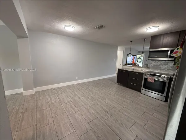 an empty room with wooden floor and mirror