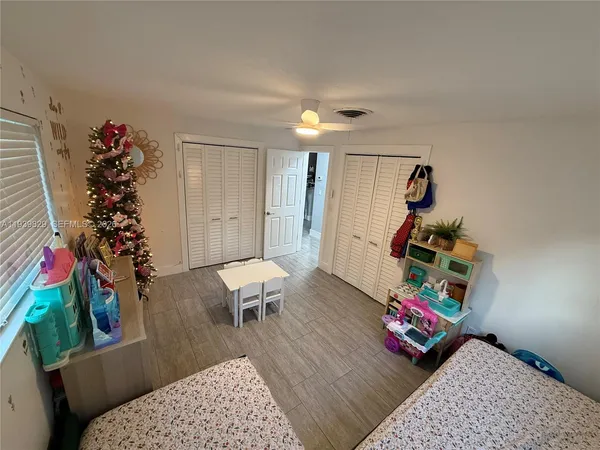 a bedroom with a bed and a flat tv screen on the dresser