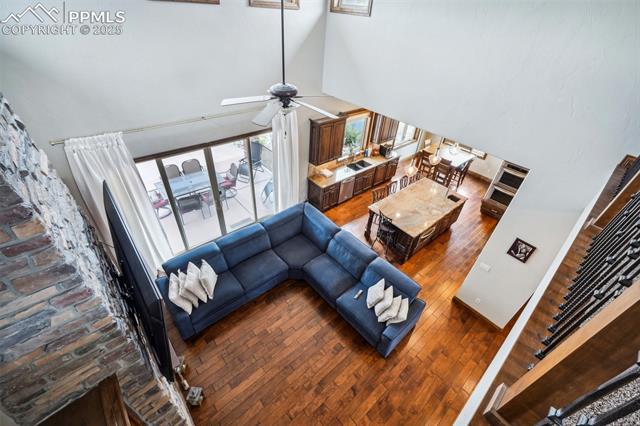13665 Random Ridge View Colorado Springs, CO 80921 - Photo 11 of 49 Living room with hardwood / wood-style floors, a high ceiling, and ceiling fan
