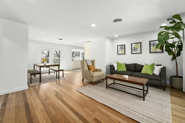 a living room with furniture and a wooden floor