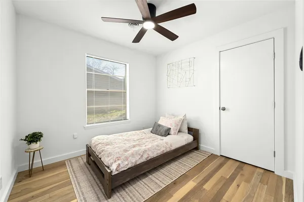 a bedroom with a bed potted plant with the window