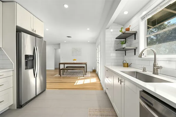 a kitchen with stainless steel appliances a sink and a refrigerator