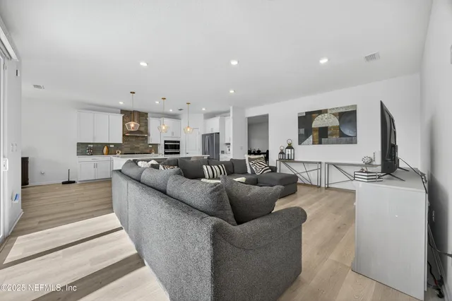 a large kitchen with stainless steel appliances kitchen island granite countertop a stove a refrigerator a sink and a oven