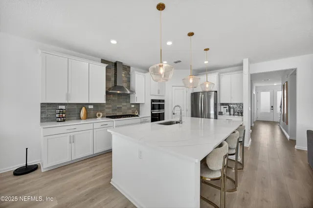 a kitchen with kitchen island a sink appliances and cabinets