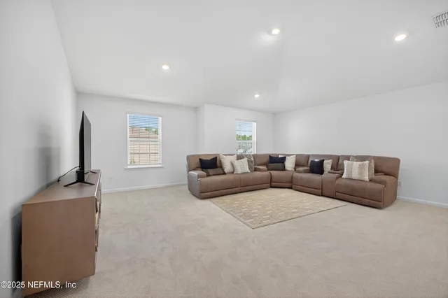 a spacious bedroom with a bed and a television