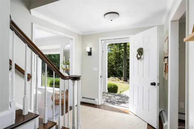 a view of entryway with wooden floor and livingroom view