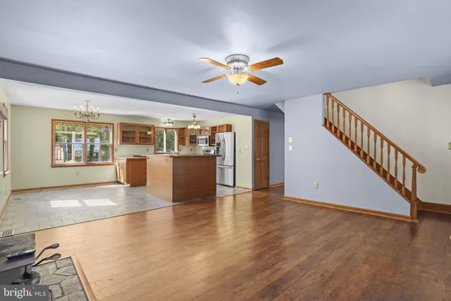 a view of a livingroom with wooden floor and a ceiling fan
