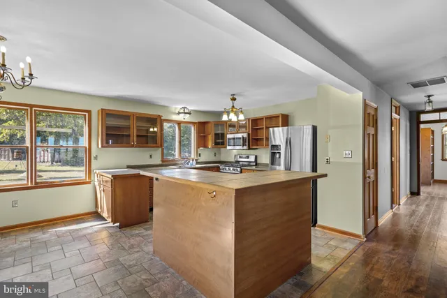 a kitchen with stainless steel appliances granite countertop a refrigerator stove top oven and sink