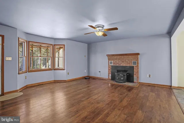a view of an empty room with a window and fireplace