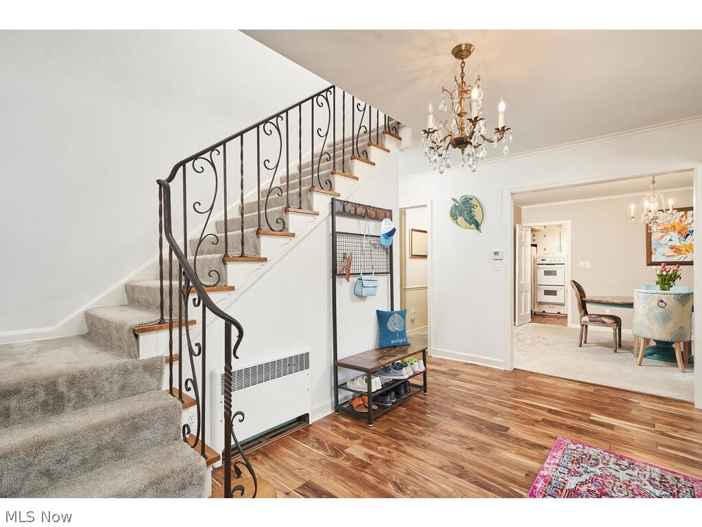2253 Tinkham Road Akron, OH 44313 - Photo 7 of 31 Stairs featuring a chandelier, hardwood / wood-style flooring, and radiator heating unit