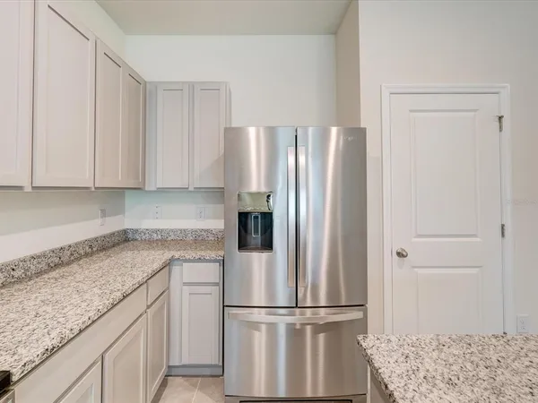 a kitchen with a refrigerator and cabinets