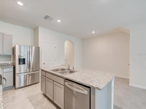 a kitchen with stainless steel appliances granite countertop a sink and refrigerator