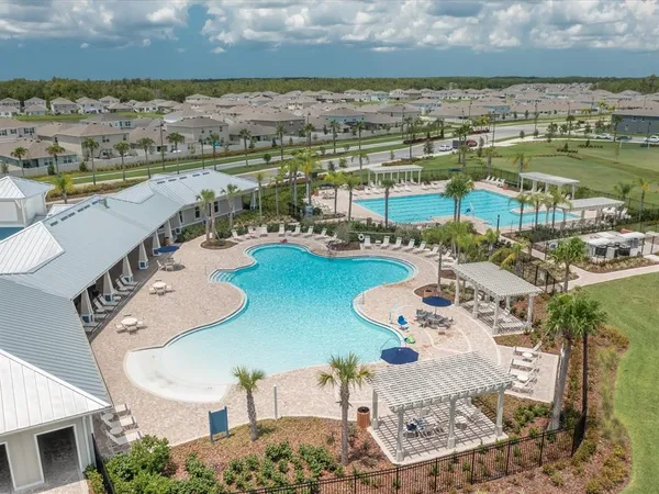 an aerial view of residential houses with outdoor space and swimming pool