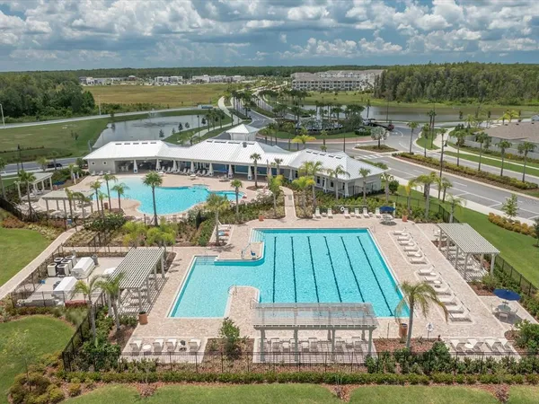 an aerial view of a house with a swimming pool and outdoor seating