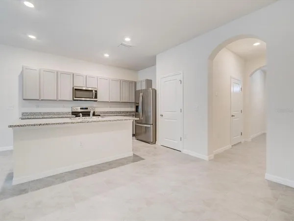 a kitchen with stainless steel appliances granite countertop white cabinets and refrigerator