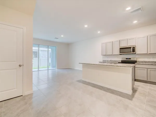 a kitchen with white cabinets and appliances