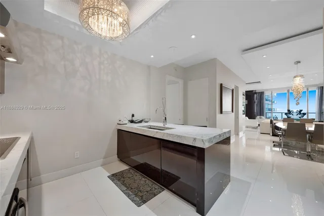 a kitchen with kitchen island a counter top space a sink stainless steel appliances and cabinets