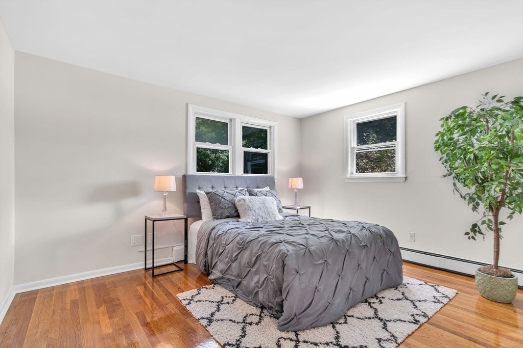 5 Robin Circle Westborough, MA 01581 - Photo 9 of 29 a bedroom with a bed lamp and a potted plant