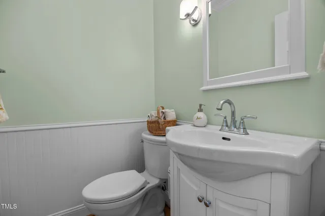 a bathroom with a sink a toilet and mirror