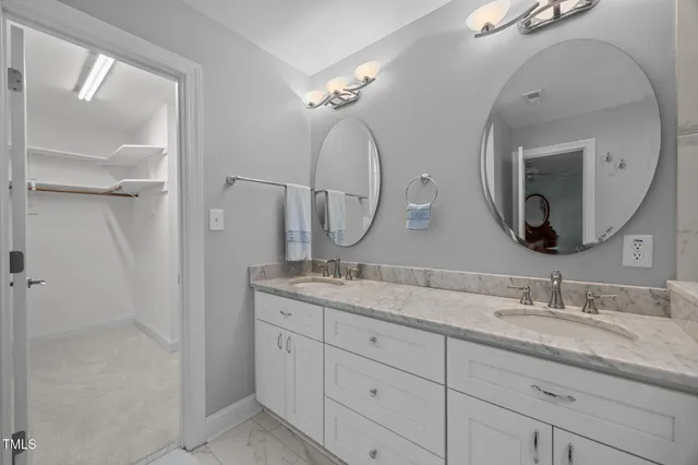 a en suite bathroom with a double vanity sink and a mirror