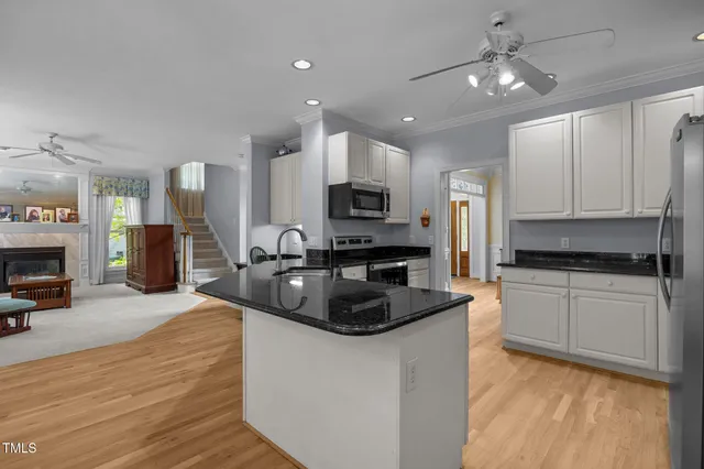 a kitchen with granite countertop a stove top oven a sink a counter top space and cabinets