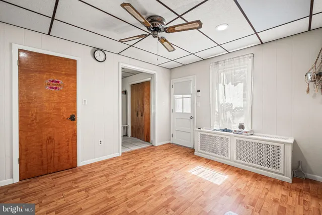 a large white kitchen with wooden floor and window