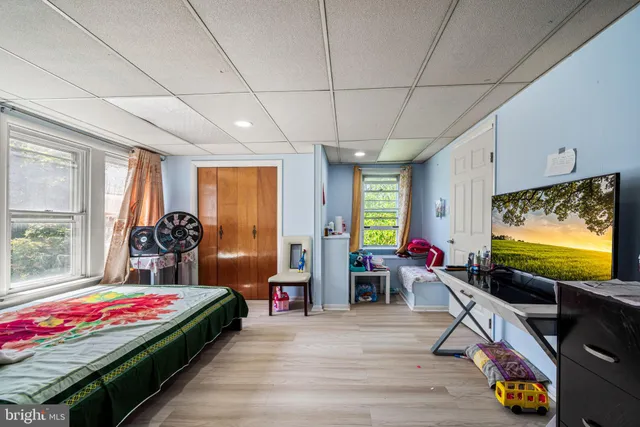 a living room with furniture flat screen tv and a large window