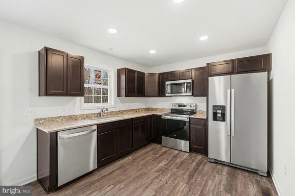 a kitchen with stainless steel appliances granite countertop refrigerator sink and microwave