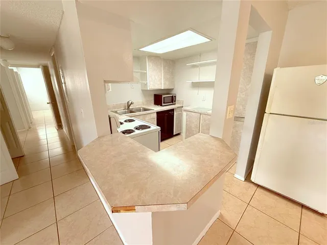 a kitchen with a sink a stove top oven and white cabinets