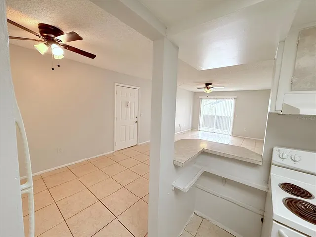 an empty room with windows and fan
