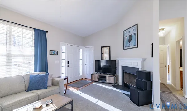a living room with furniture a flat screen tv and a fireplace