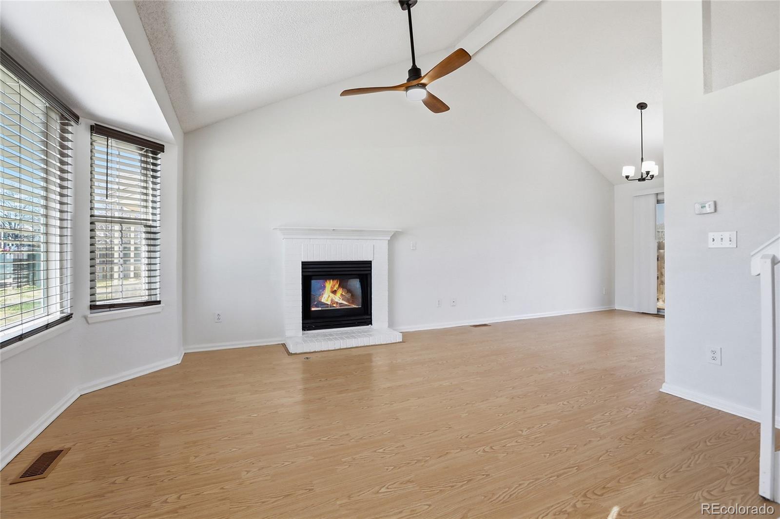 4381 Perth Circle Denver, CO 80249 - Photo 2 of 35 a view of an empty room with a fireplace and a window