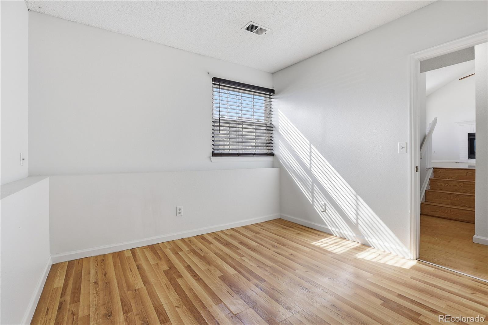 4381 Perth Circle Denver, CO 80249 - Photo 21 of 35 a view of an empty room with wooden floor and a window