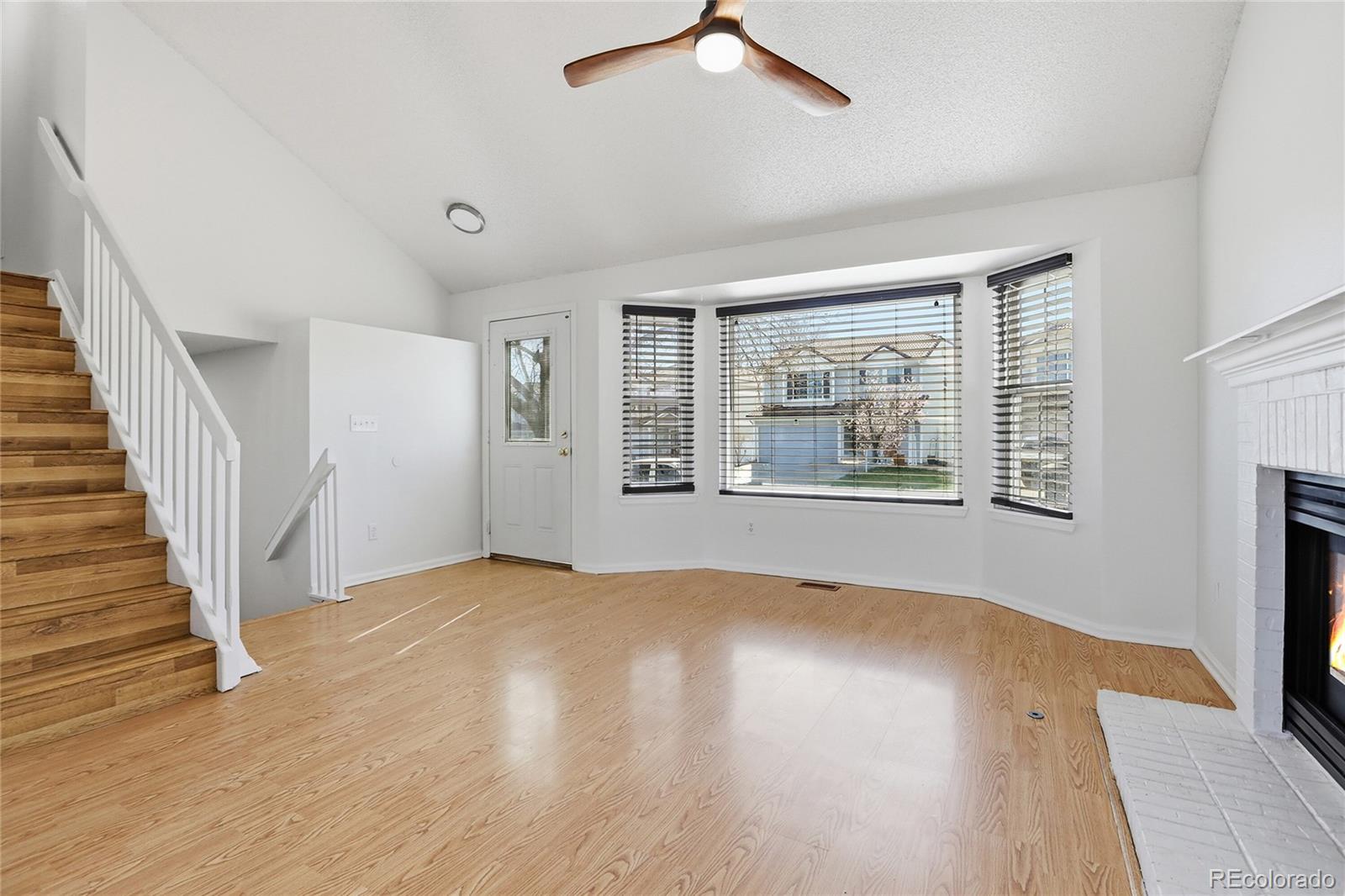 4381 Perth Circle Denver, CO 80249 - Photo 4 of 35 a view of an empty room with wooden floor and a window