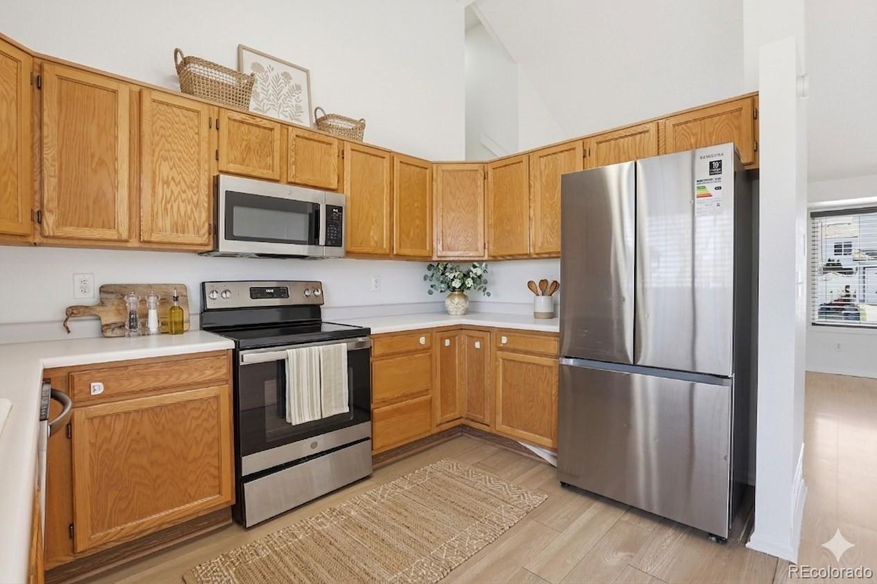 4381 Perth Circle Denver, CO 80249 - Photo 5 of 35 a kitchen with stainless steel appliances granite countertop a refrigerator microwave and sink