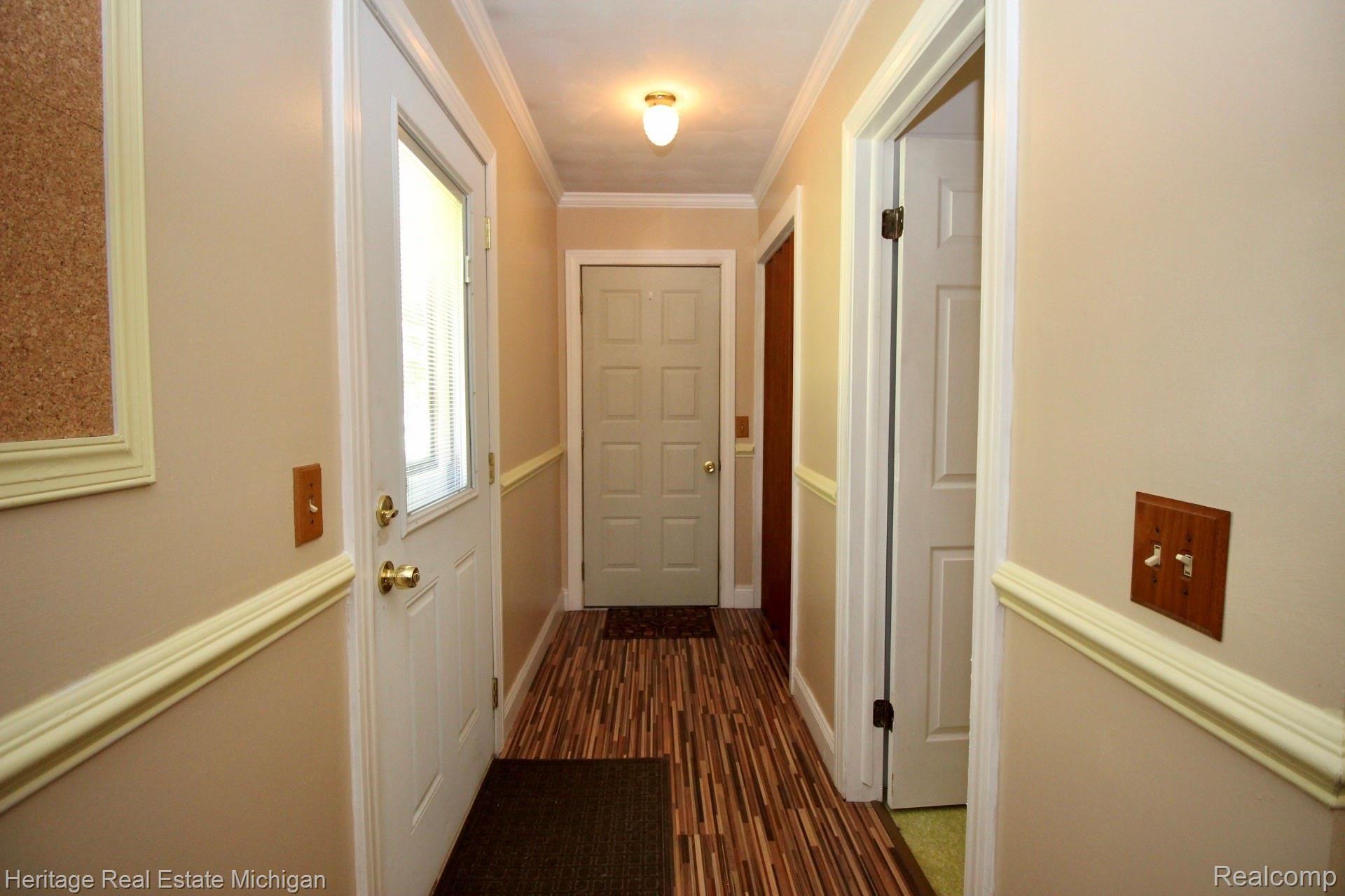 12701 Byron Road Byron, MI 48418 - Photo 23 of 54 Hallway leading to front entrance, laundry room/half bath, basement, and garage