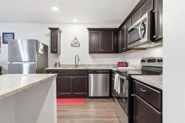 a kitchen with stainless steel appliances granite countertop a sink stove and refrigerator