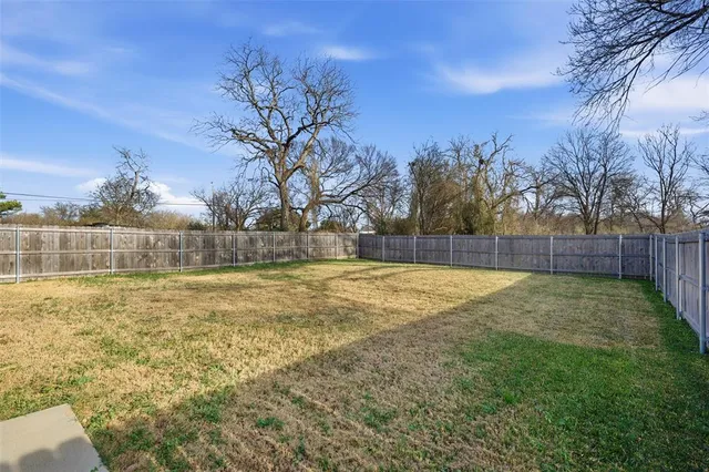 a view of yard with swimming pool and wooden fence