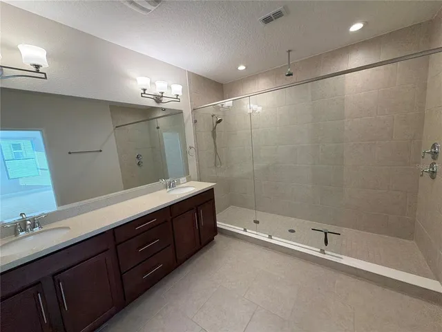 a bathroom with a double vanity sink toilet and shower