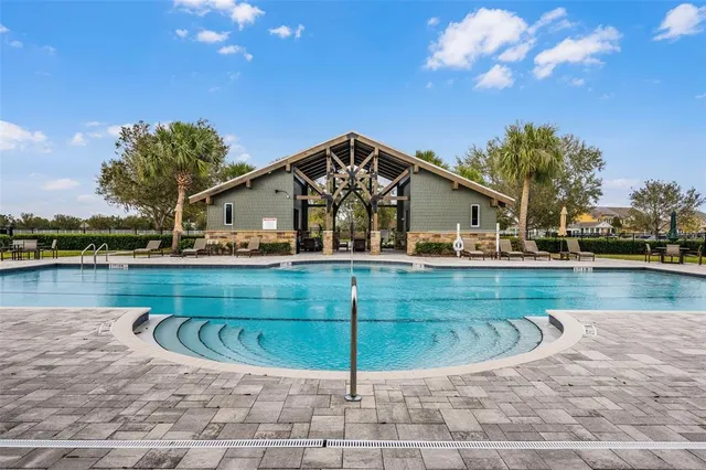 a view of house with patio outdoor seating and covered with trees