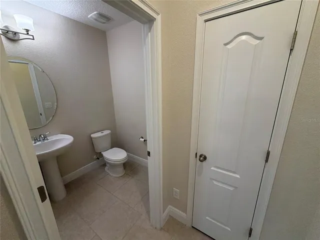 a bathroom with a granite countertop toilet and a sink
