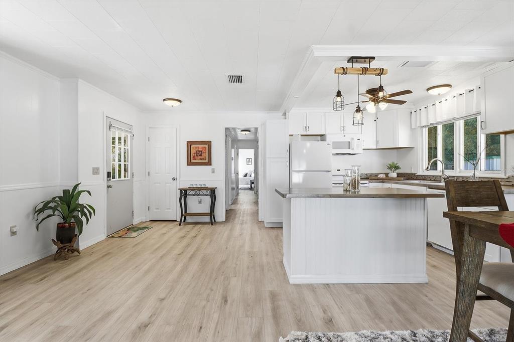1050 North Midiron Point Crystal River, FL 34429 - Photo 12 of 57 a open kitchen with granite countertop a refrigerator a stove a sink dishwasher and white cabinets with wooden floor