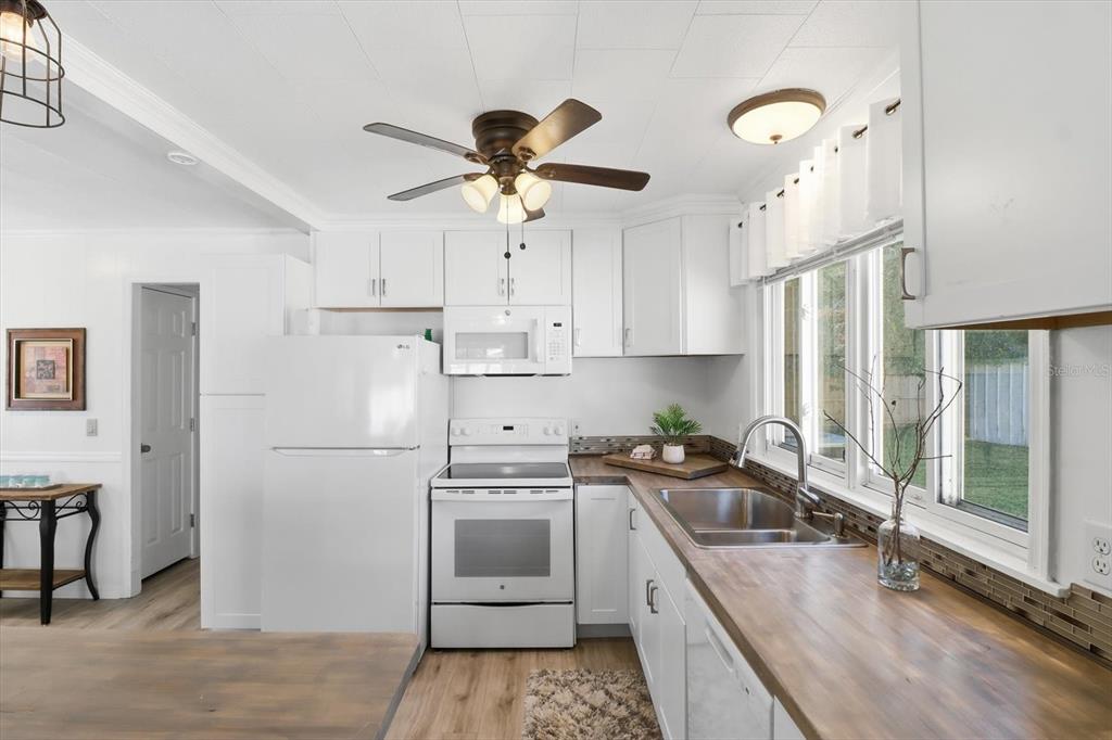1050 North Midiron Point Crystal River, FL 34429 - Photo 14 of 57 a kitchen with stainless steel appliances a stove a sink dishwasher a refrigerator and white cabinets with wooden floor