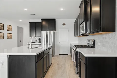 a kitchen with stainless steel appliances granite countertop a sink stove and refrigerator
